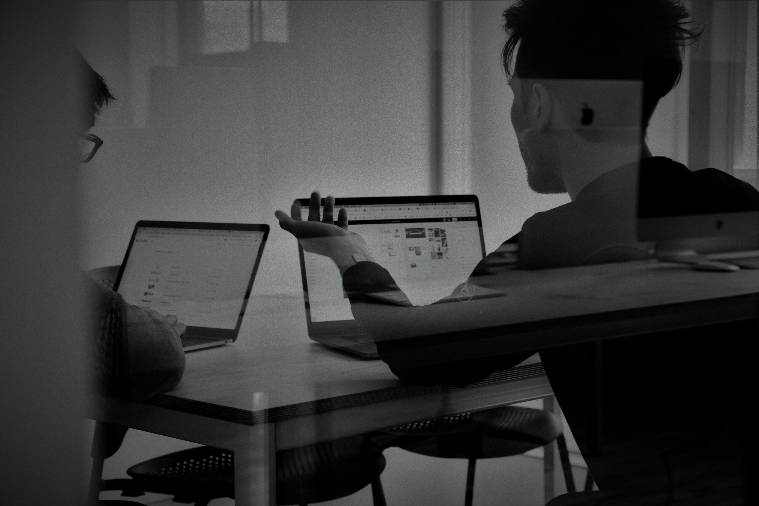 dos personas trabajando en sus ordenadores portatiles